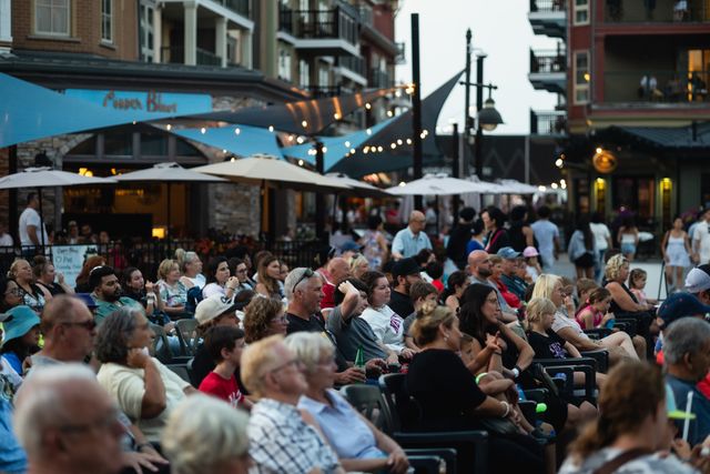 A full audience of guests seated in front of the Subaru Stage for a live performance on a summer evening at Blue.